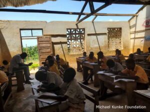 Students in a classroom with exposed roofing